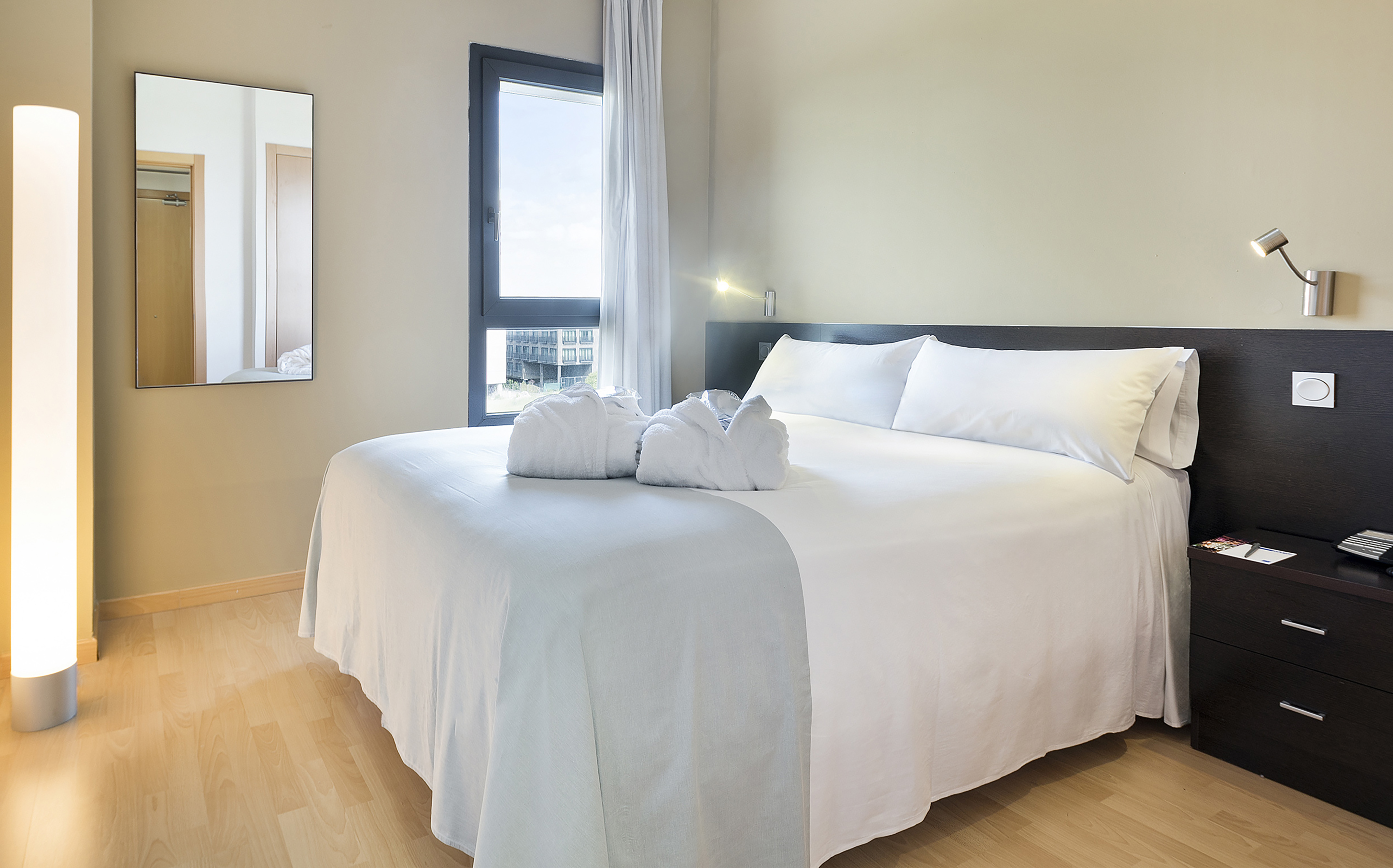 a bed with white sheets and towels