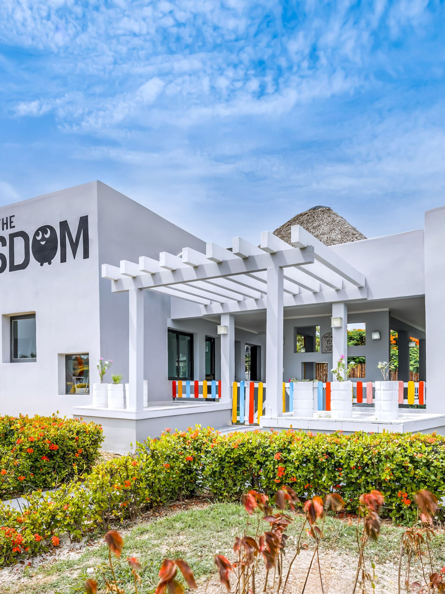 a building with a pergola and flowers