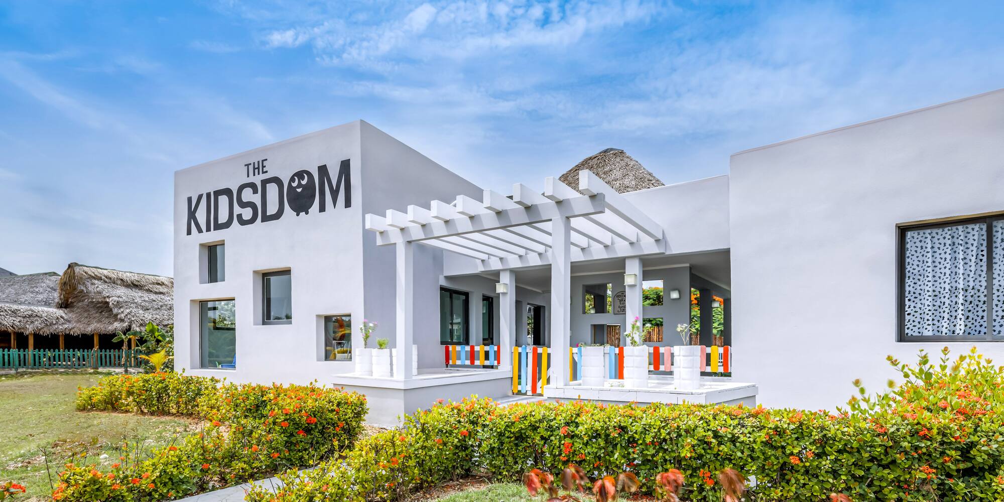 a building with a pergola and flowers