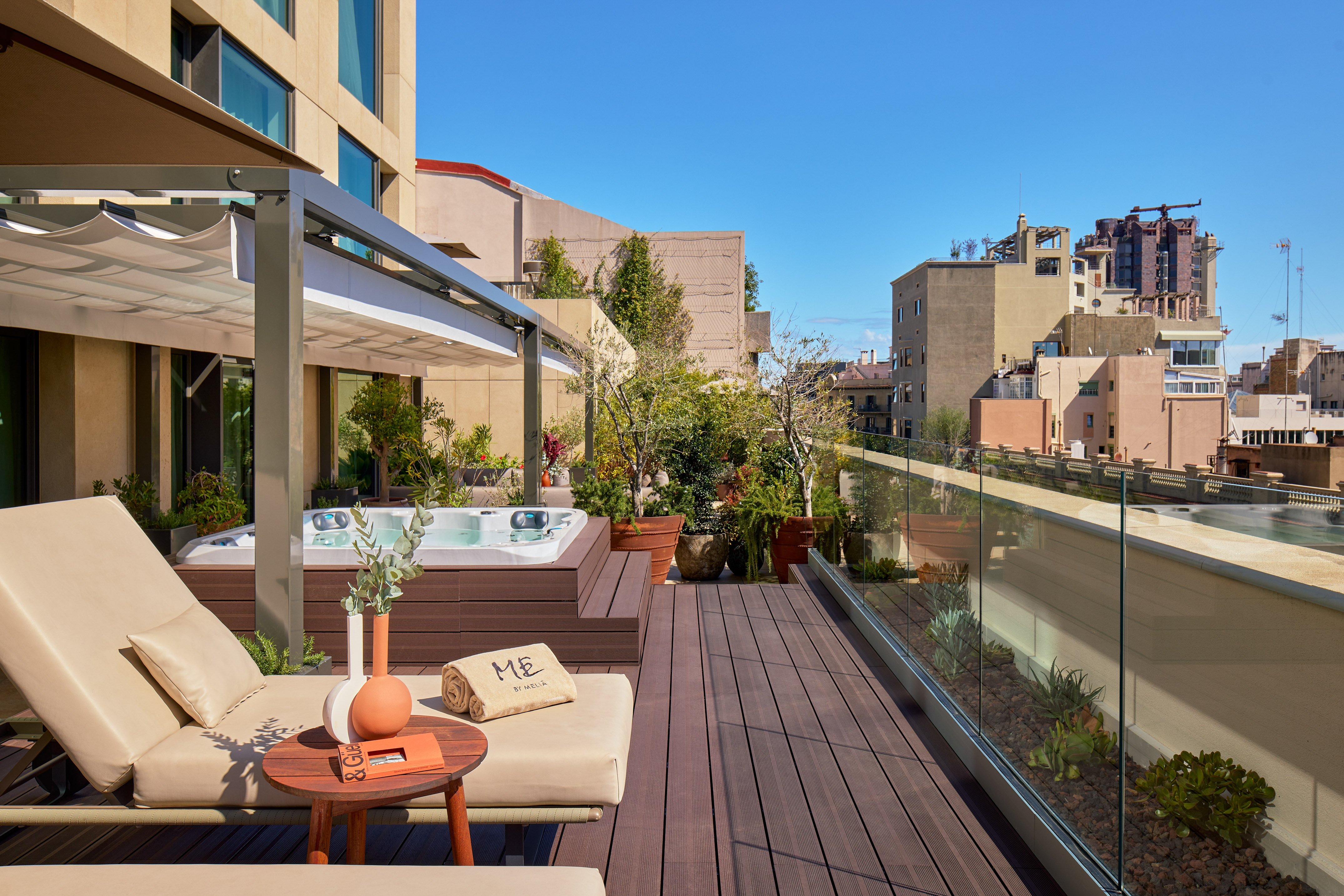 Luxurious rooftop terrace with jacuzzi, lounge chairs, pergola, and city views.