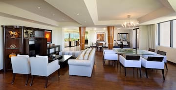 a living room with white furniture and a wood floor