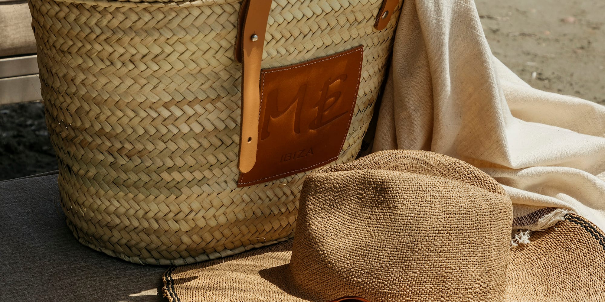 a straw hat and sunglasses next to a bag and a book