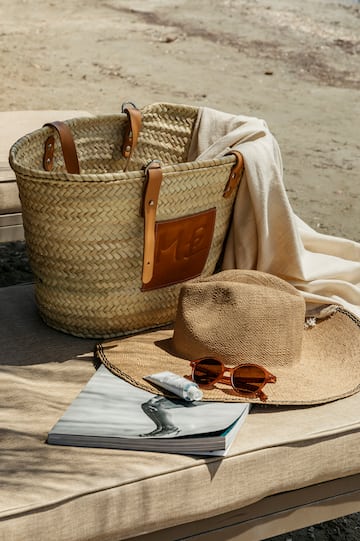 a straw hat and sunglasses next to a bag and a book