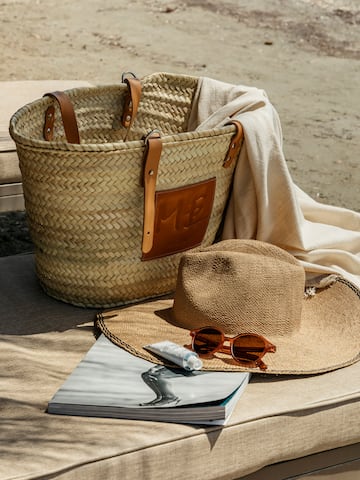 a straw hat and sunglasses next to a bag and a book