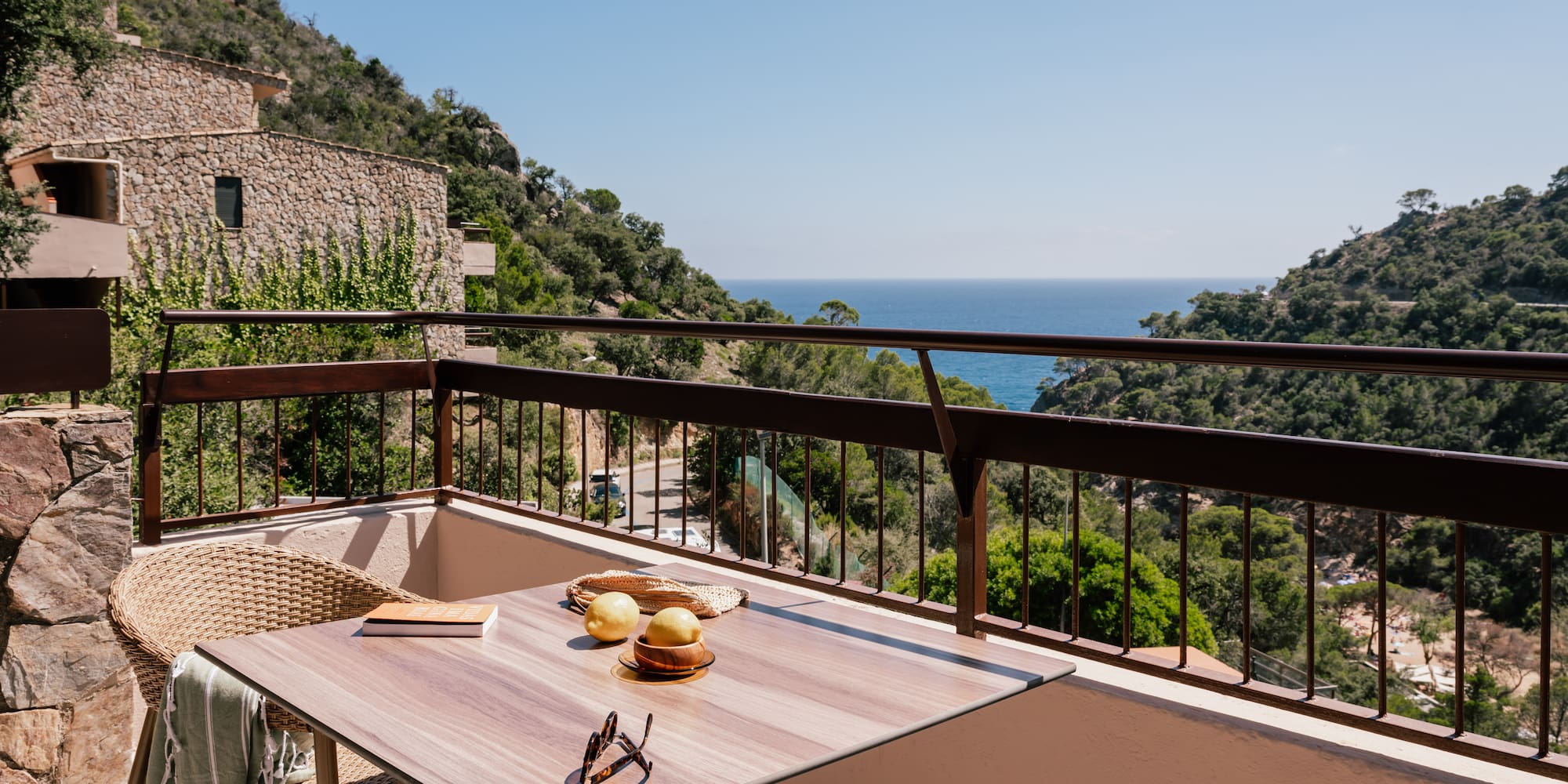 a table and chairs on a balcony overlooking a body of water