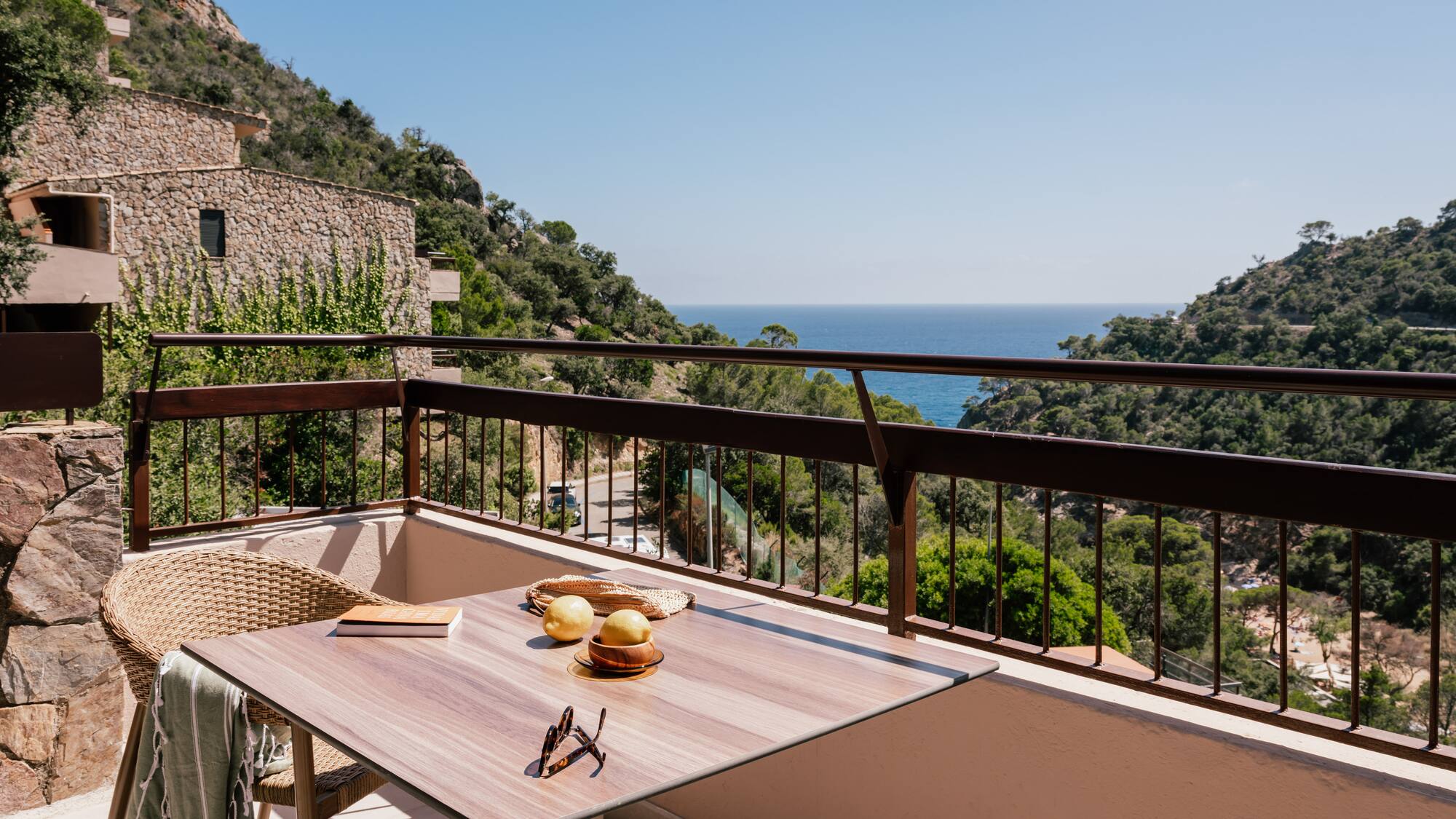 a table and chairs on a balcony overlooking a body of water