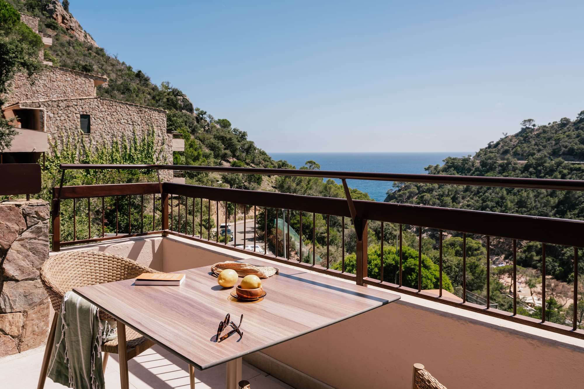 a table and chairs on a balcony overlooking a body of water