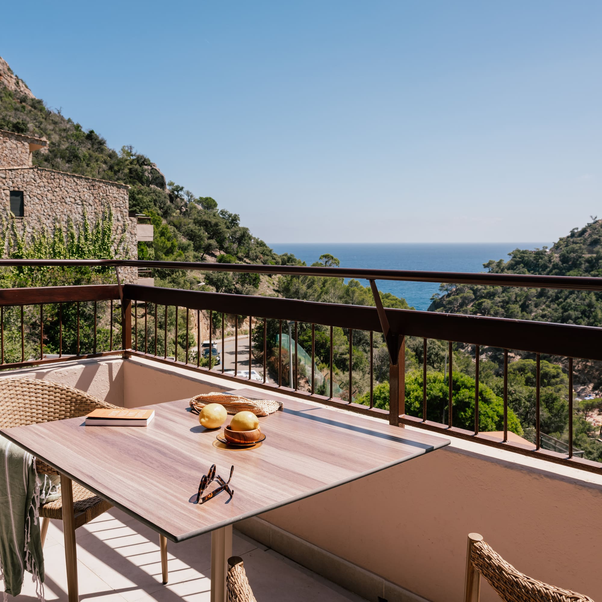 a table and chairs on a balcony overlooking a body of water