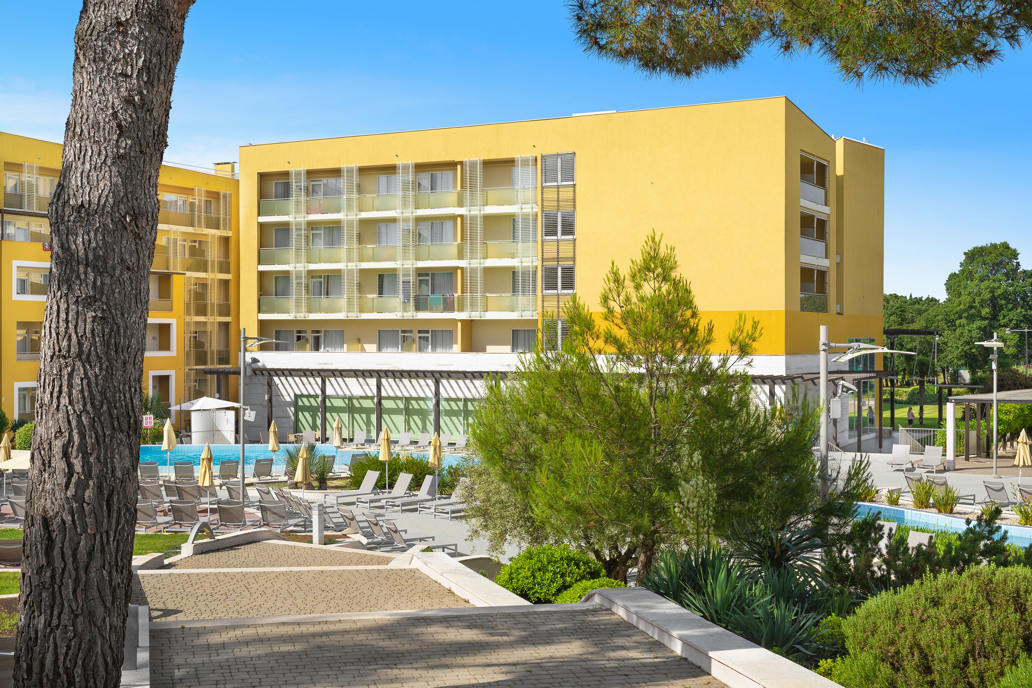 a building with a pool and trees