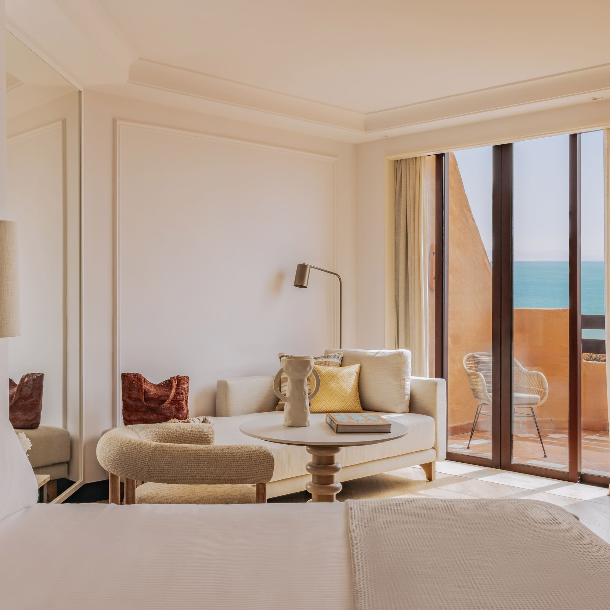 Luxury hotel suite with ocean view balcony and modern lounge.