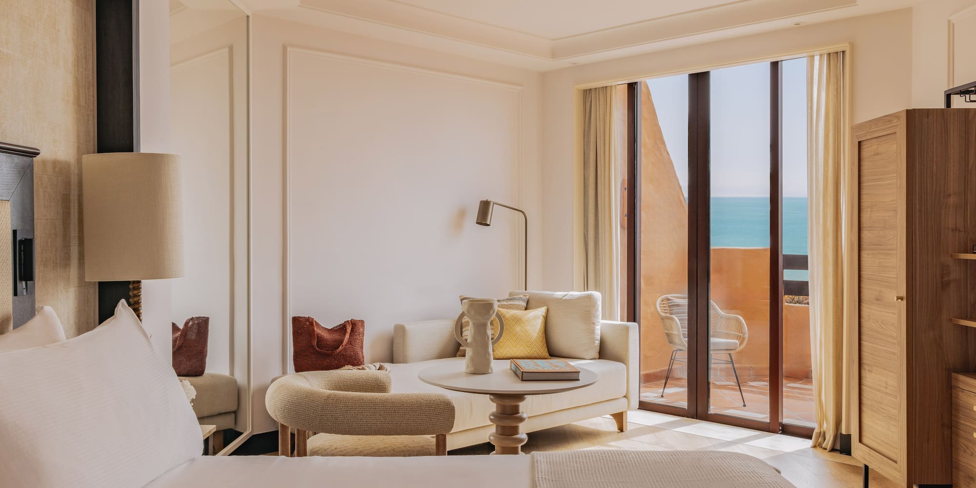 Luxury hotel suite with ocean view balcony and modern lounge.