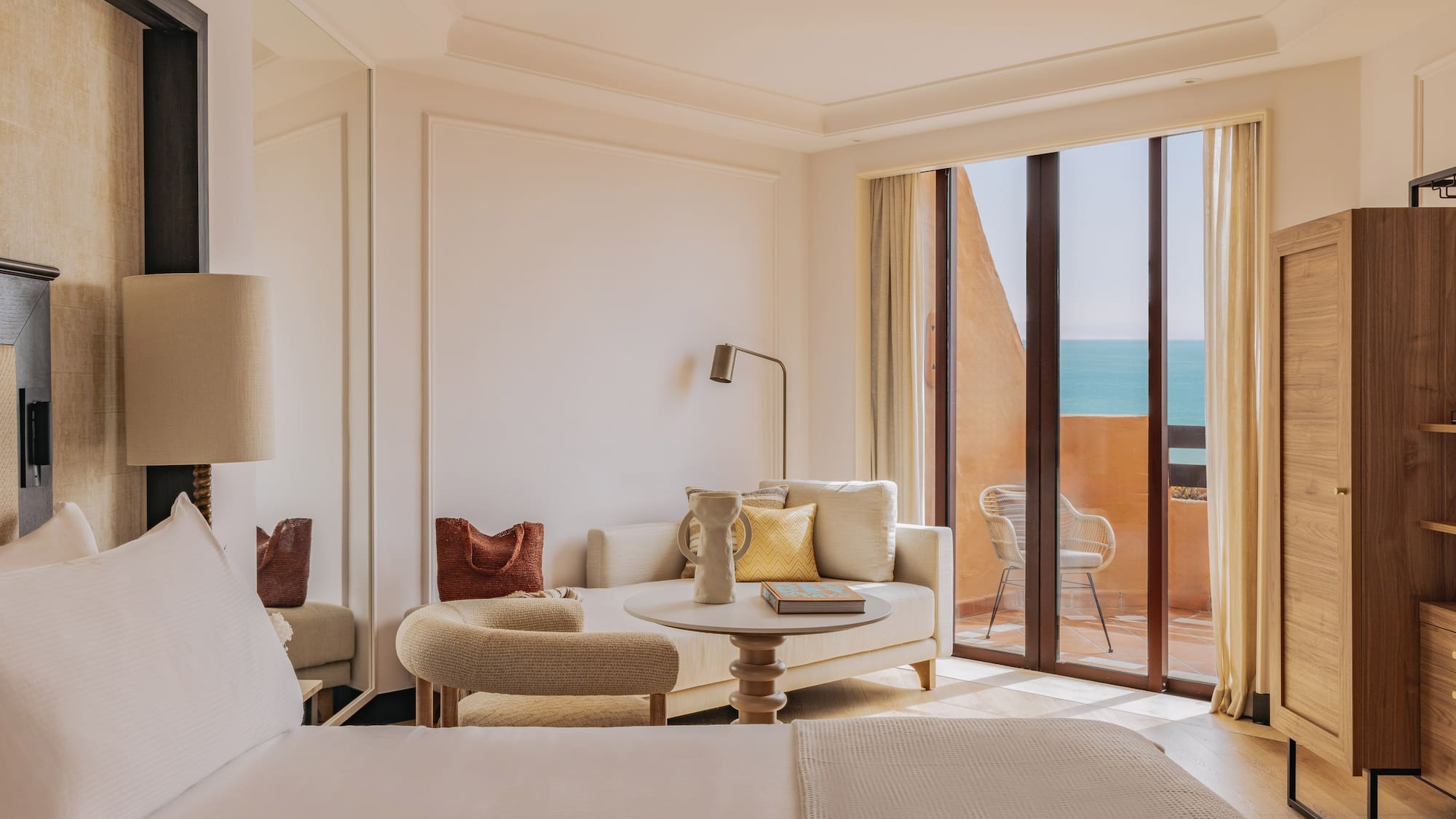 Luxury hotel suite with ocean view balcony and modern lounge.