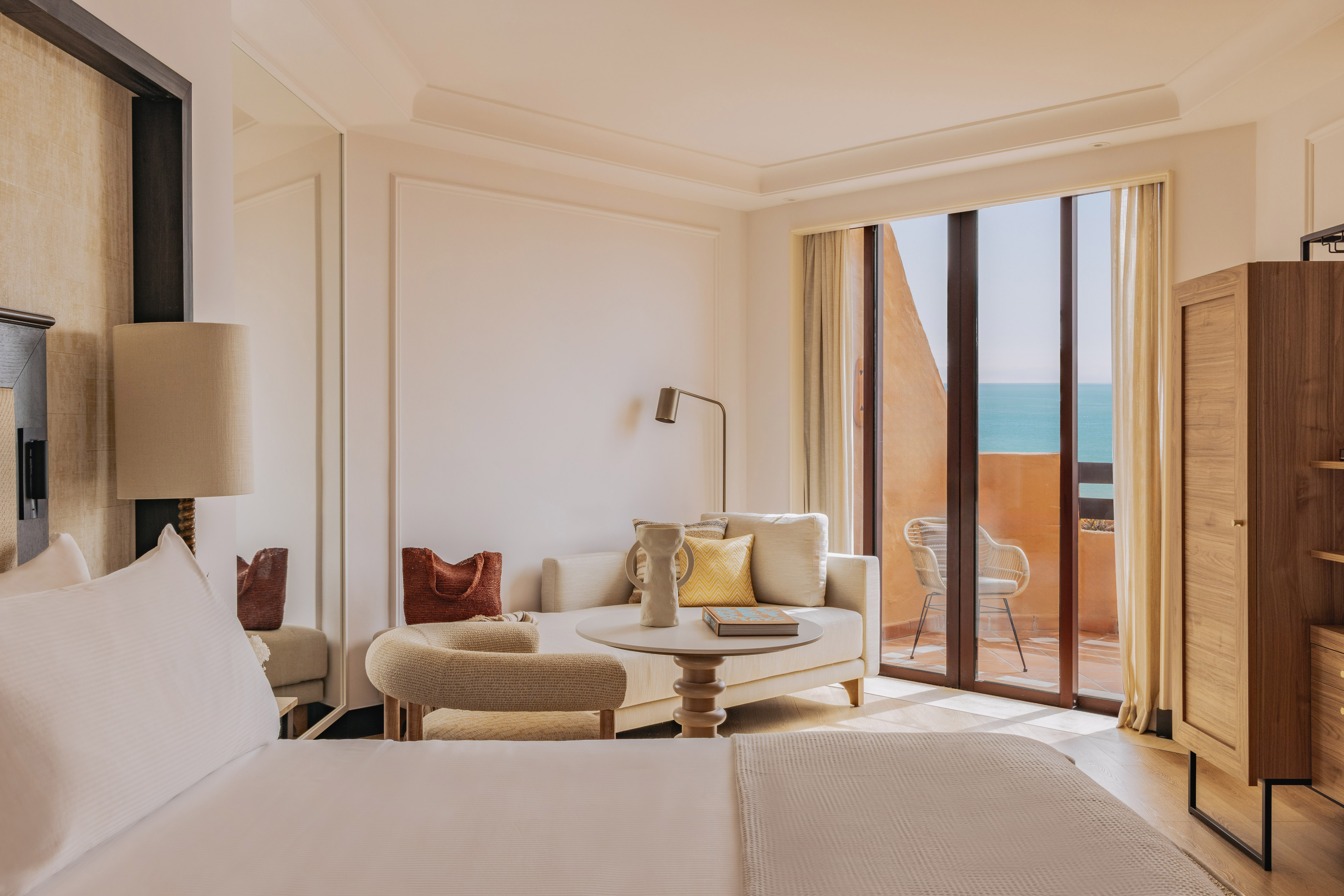 Luxury hotel suite with ocean view balcony and modern lounge.