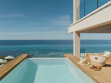 Luxury infinity pool with blue ocean view from modern villa.
