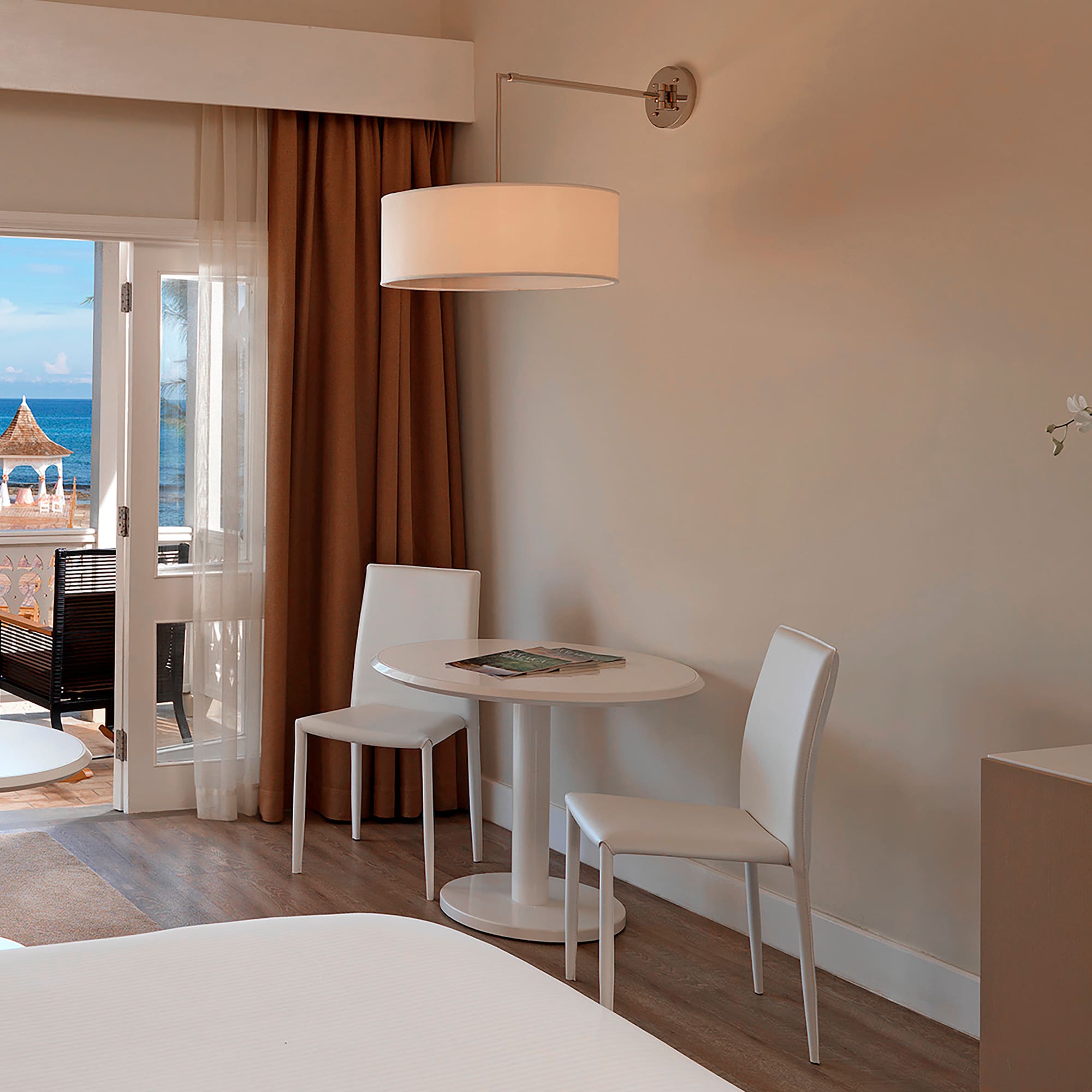 a room with a table and chairs and a door to a balcony