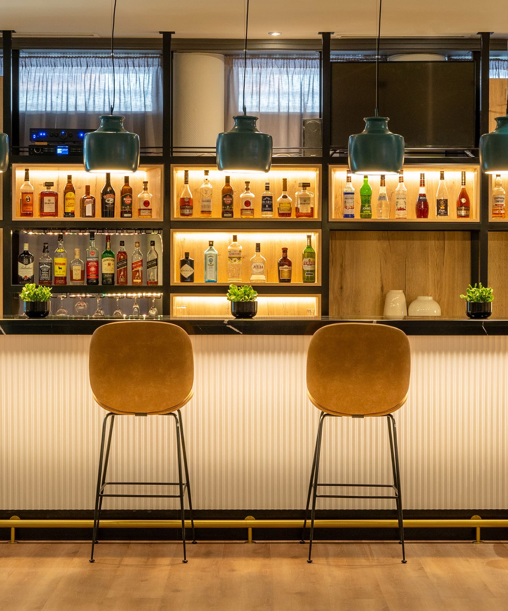 a bar with chairs and bottles on the wall
