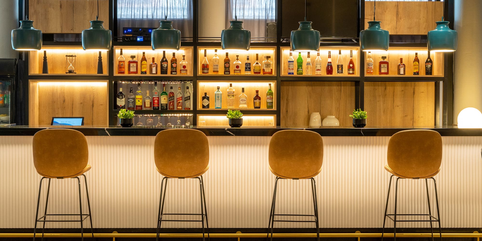 a bar with chairs and bottles on the wall