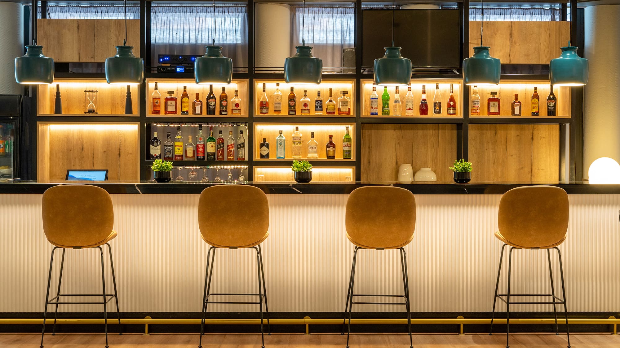 a bar with chairs and bottles on the wall