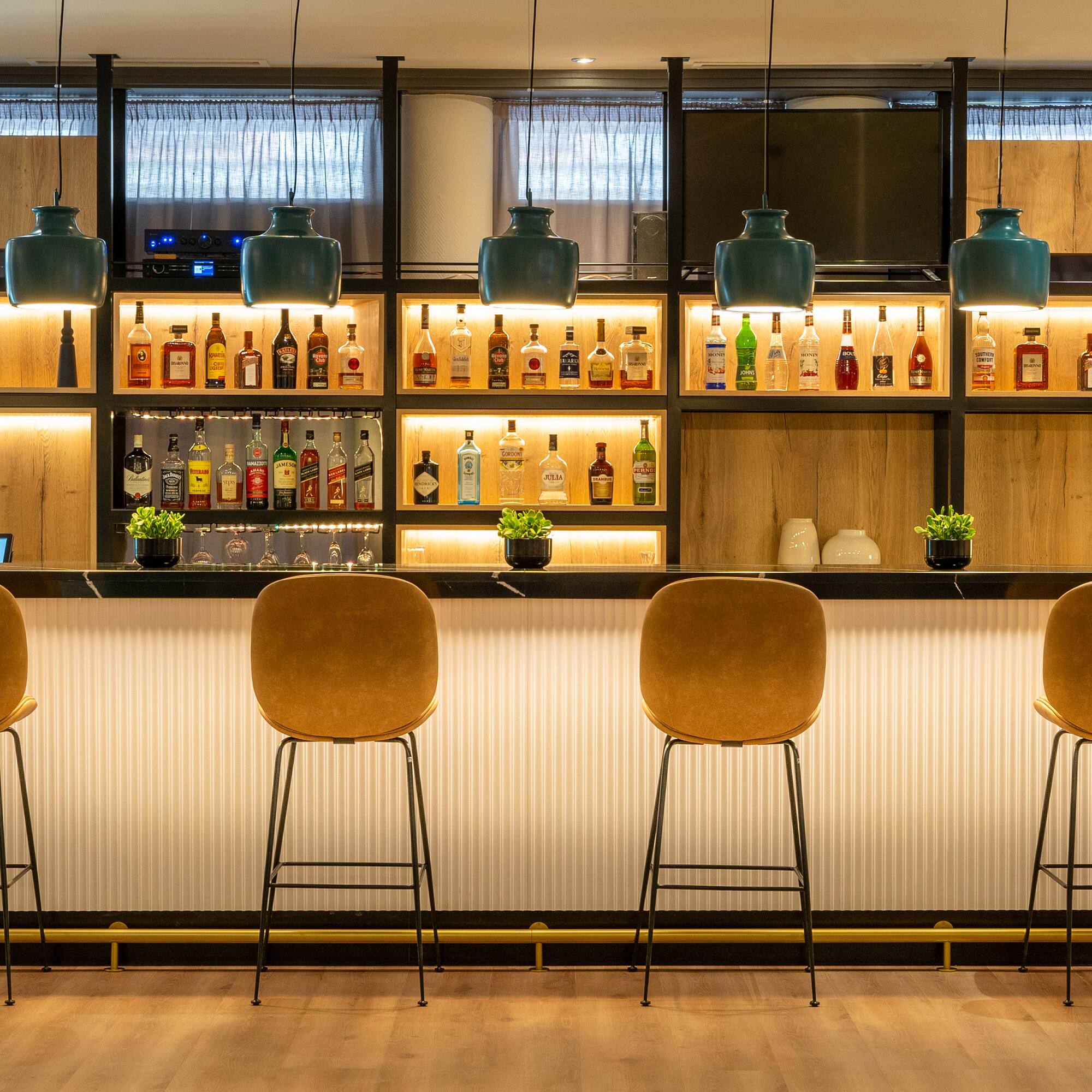 a bar with chairs and bottles on the wall