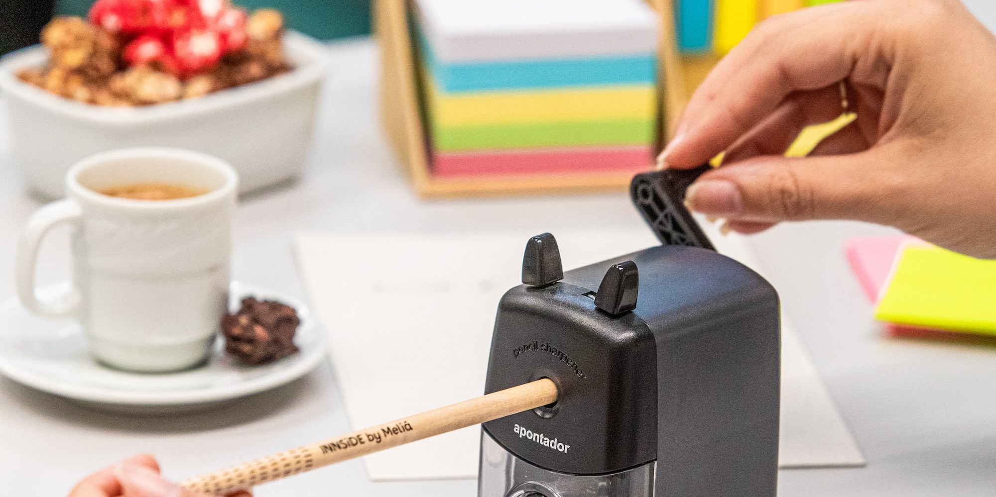 a person using a pencil to sharpen a pencil