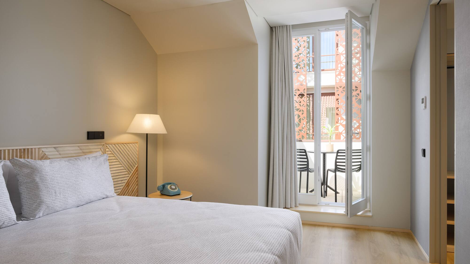 a bedroom with a bed and a door to a balcony