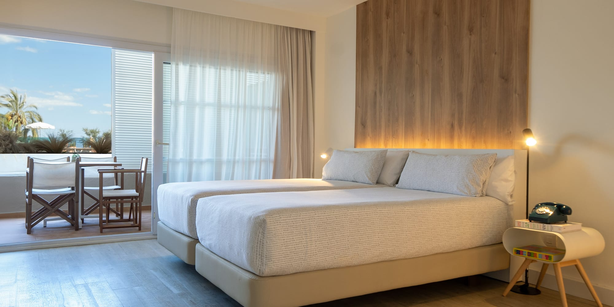 a room with two beds and a table and chairs