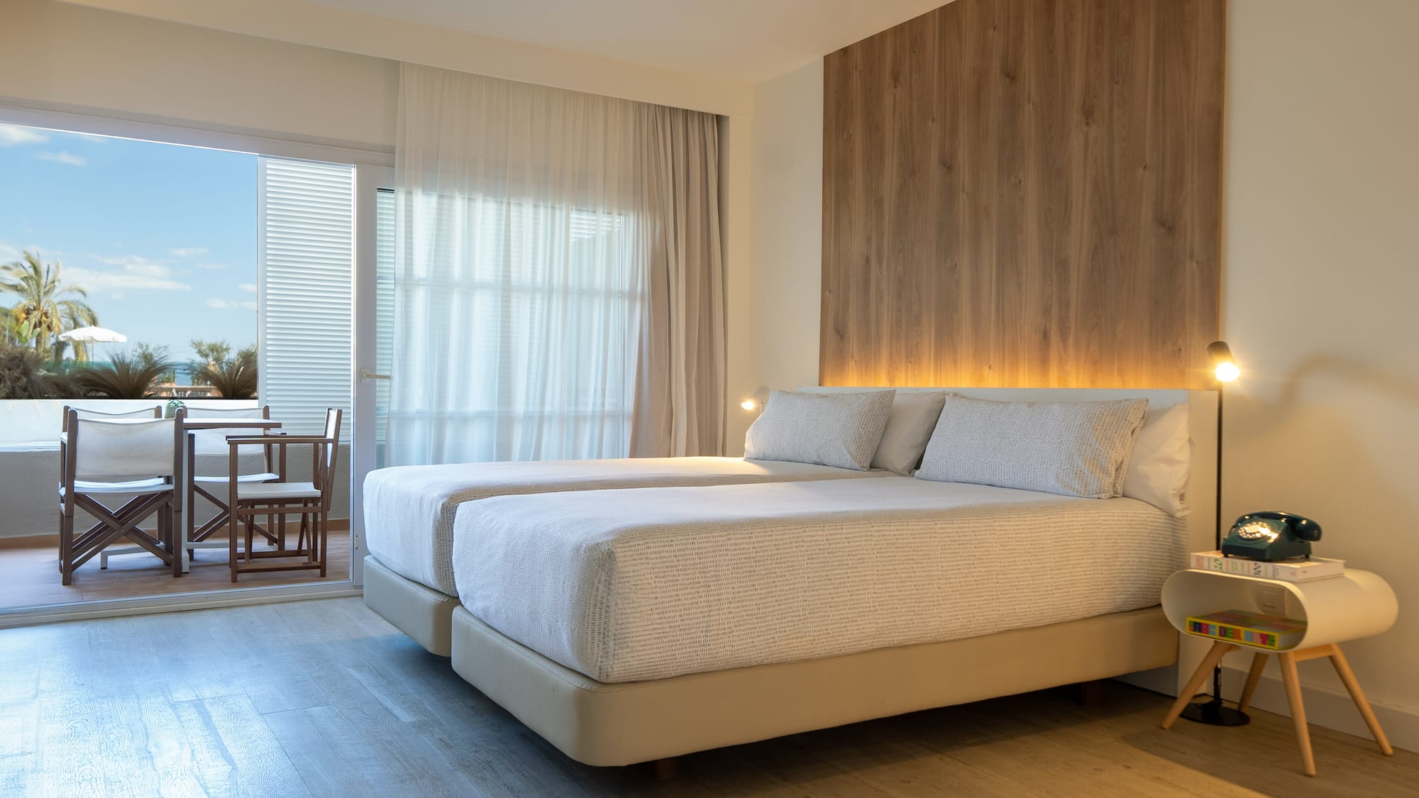 a room with two beds and a table and chairs