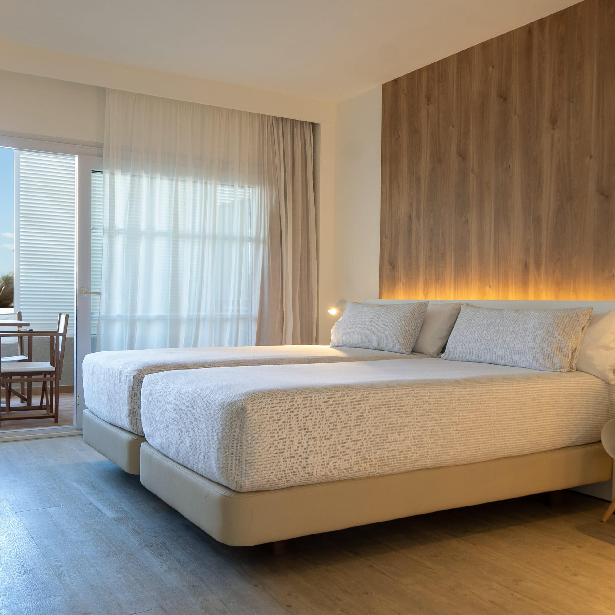 a room with two beds and a table and chairs