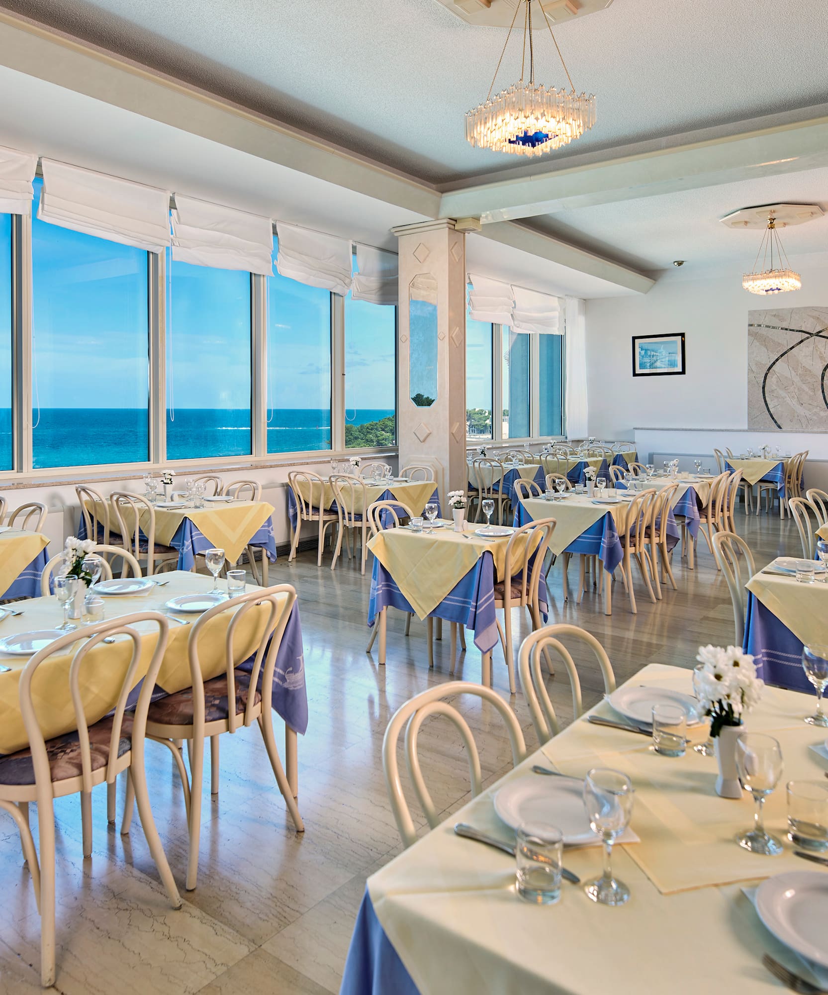 a room with tables and chairs and a chandelier