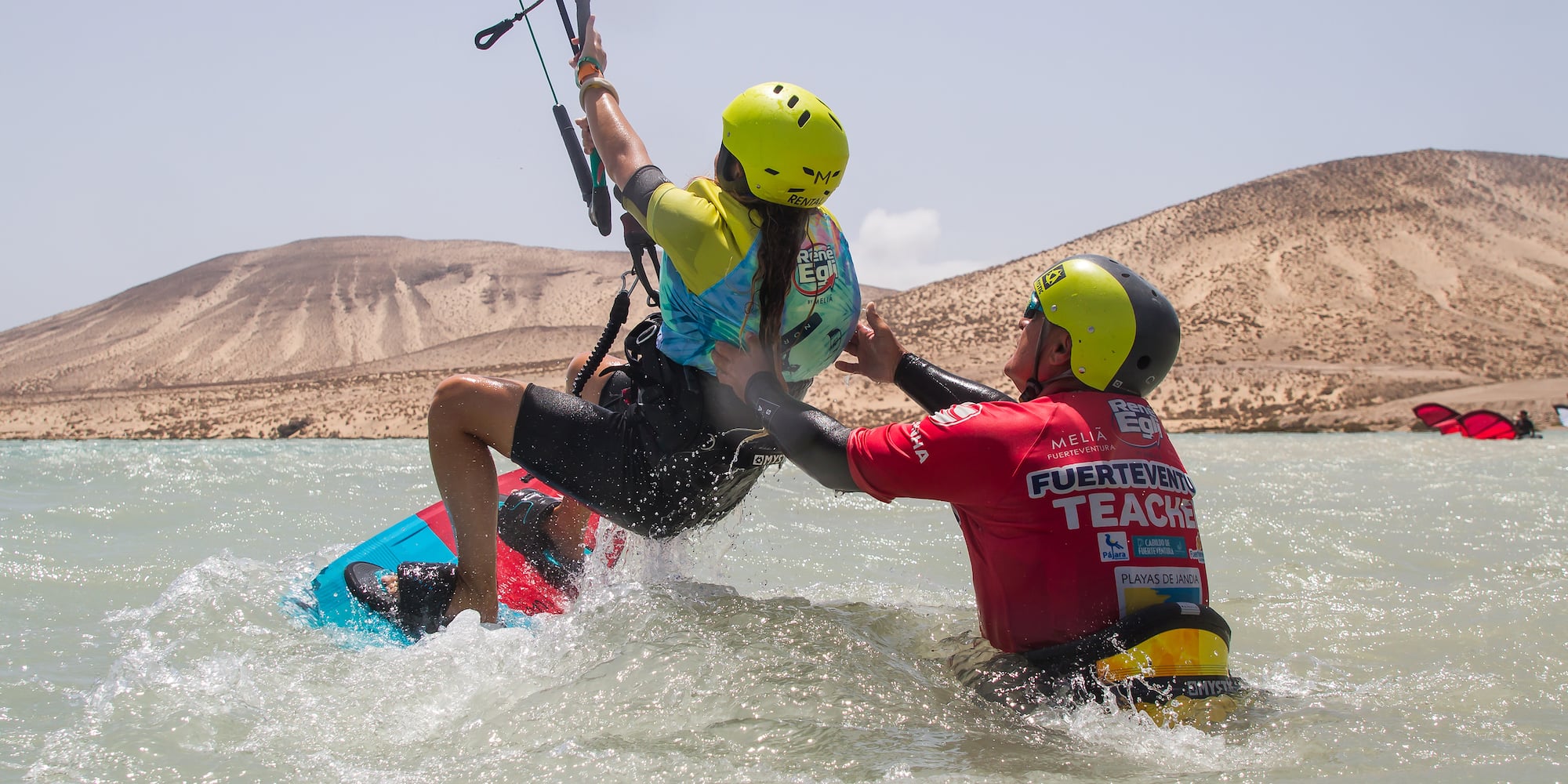 a man helping a woman to kite surfing