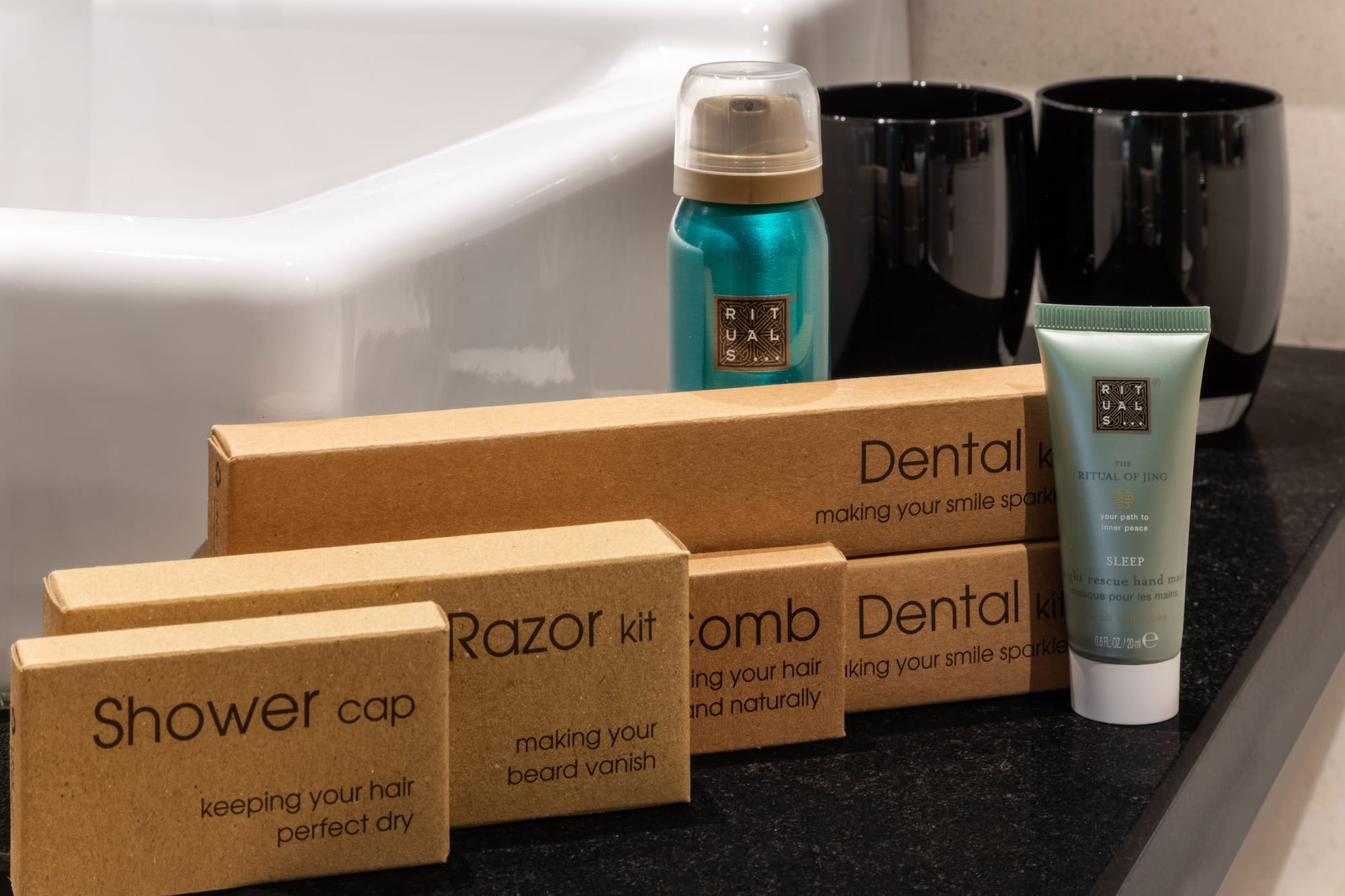 Artículos de tocador Rituals para hotel: set dental, afeitado, gorro de ducha y peine.