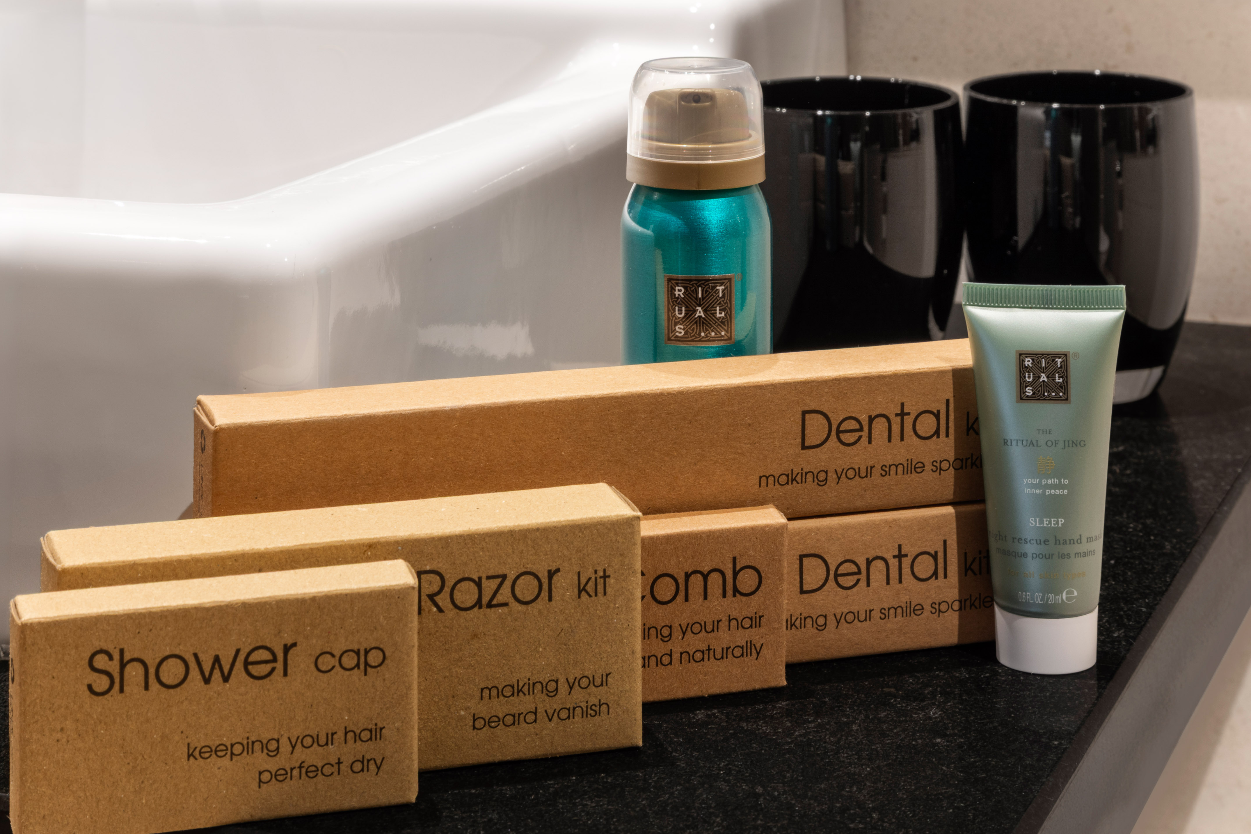 Artículos de tocador Rituals para hotel: set dental, afeitado, gorro de ducha y peine.