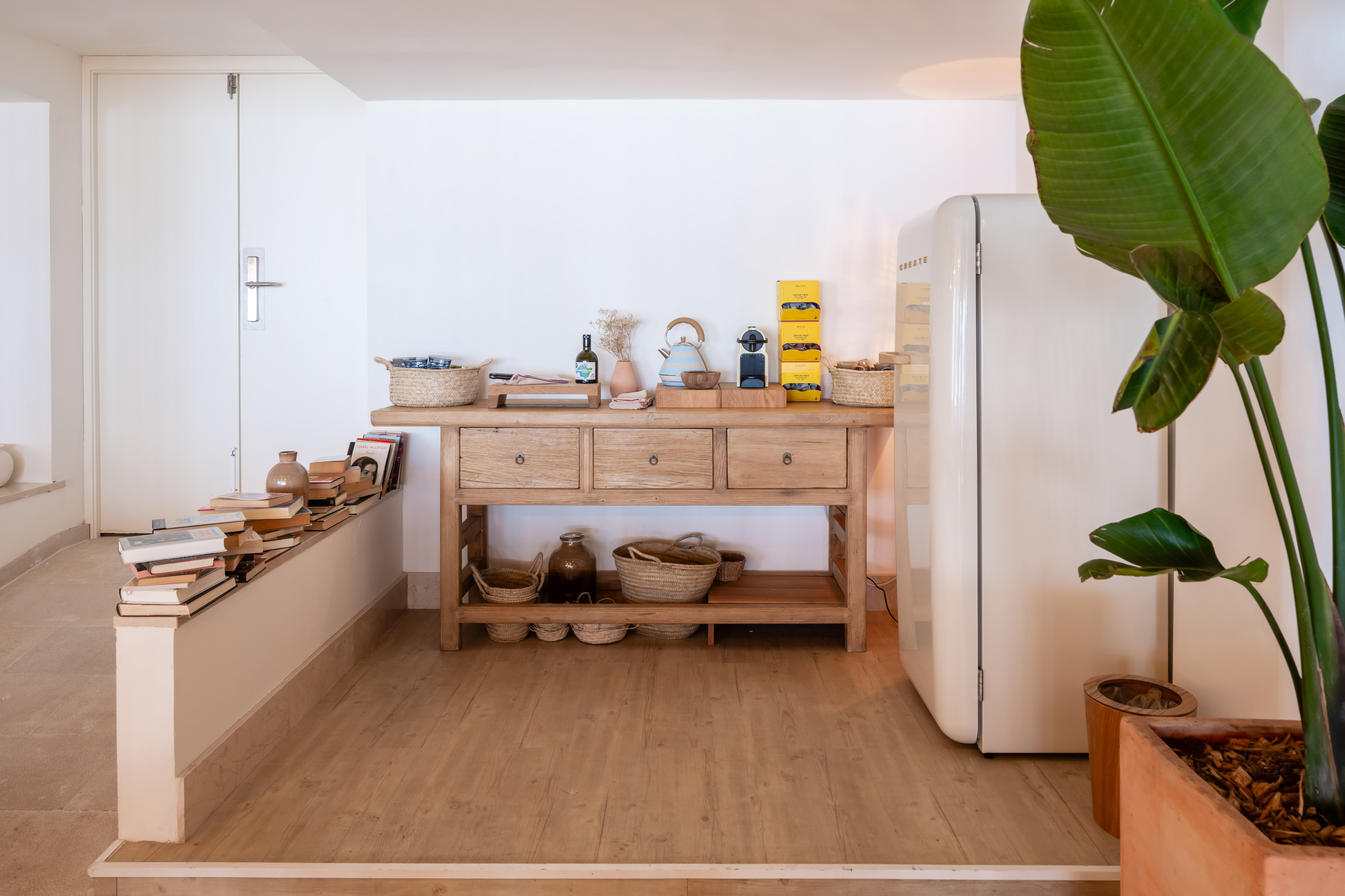 Rustic wooden console table, coffee station, vintage fridge, and potted plant.