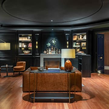 a room with a leather couch and a fireplace