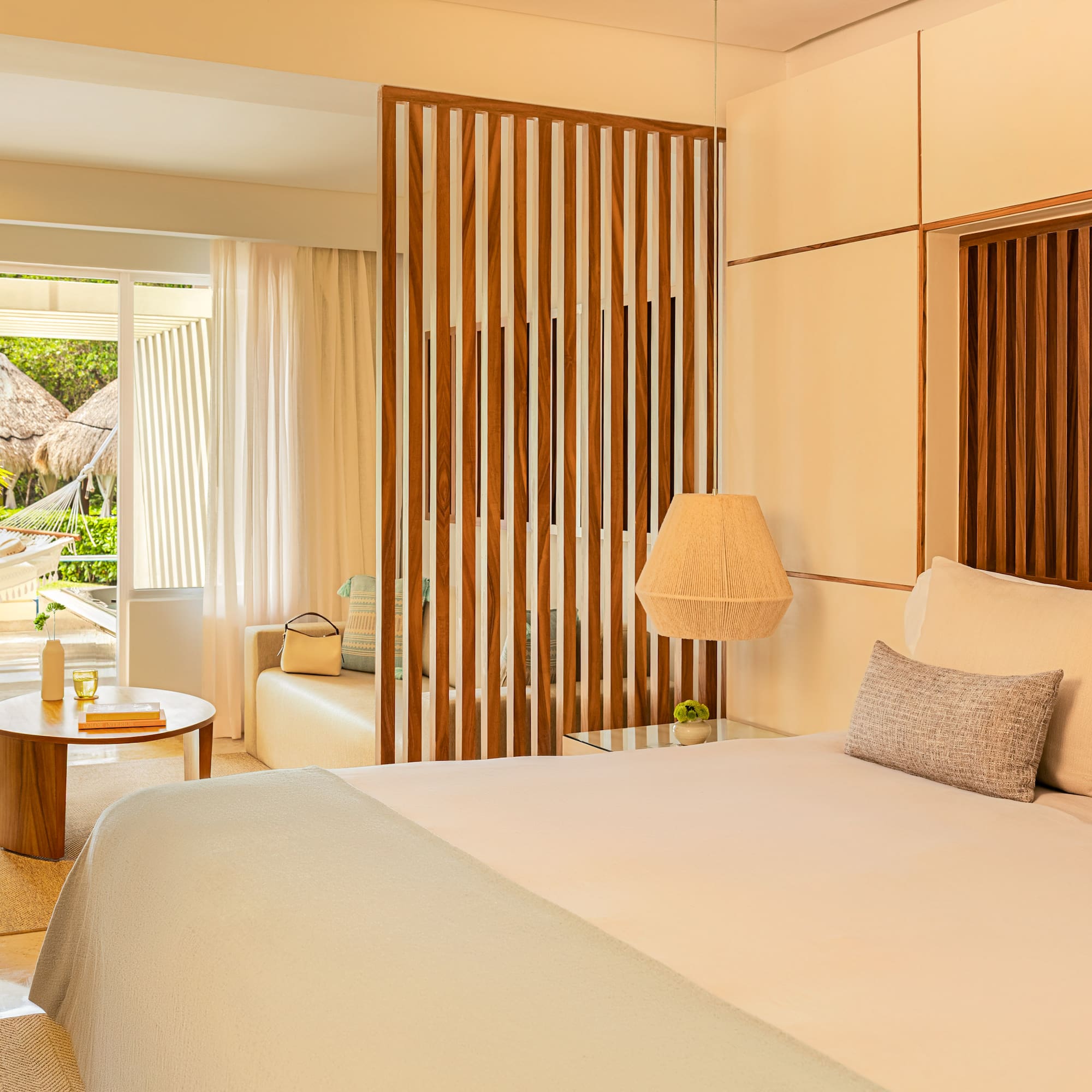 Luxury hotel bedroom with tropical patio, hammock, and garden view.