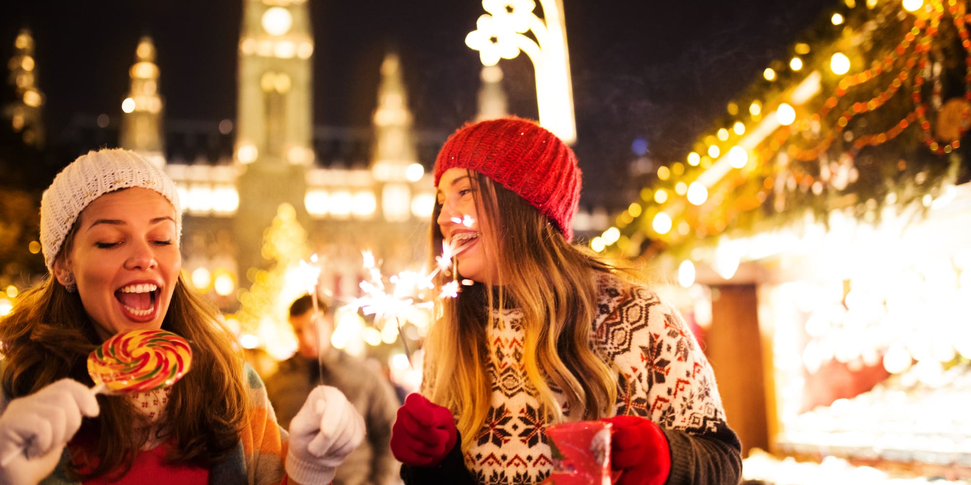 two women holding sparklers and smiling