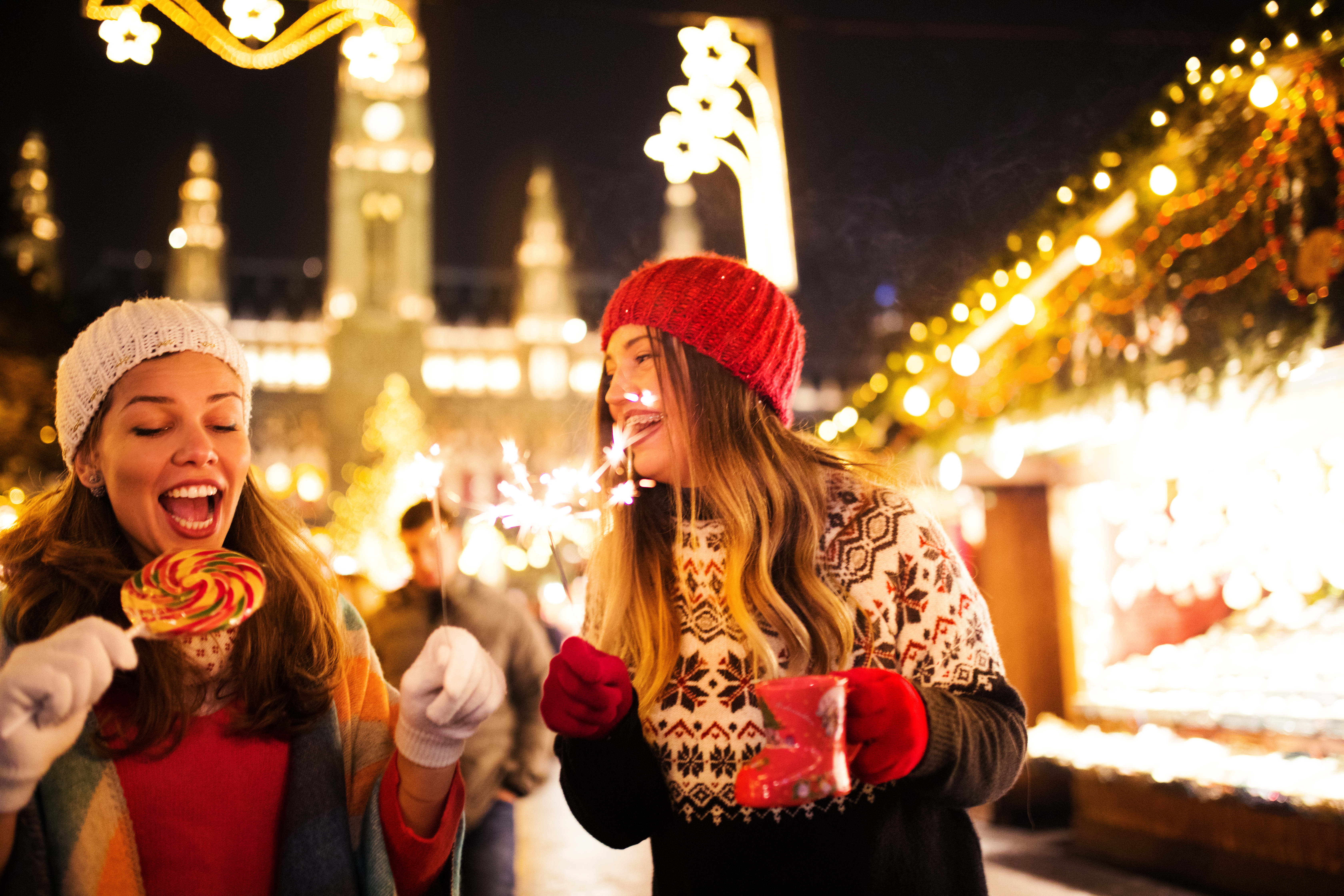 two women holding sparklers and smiling