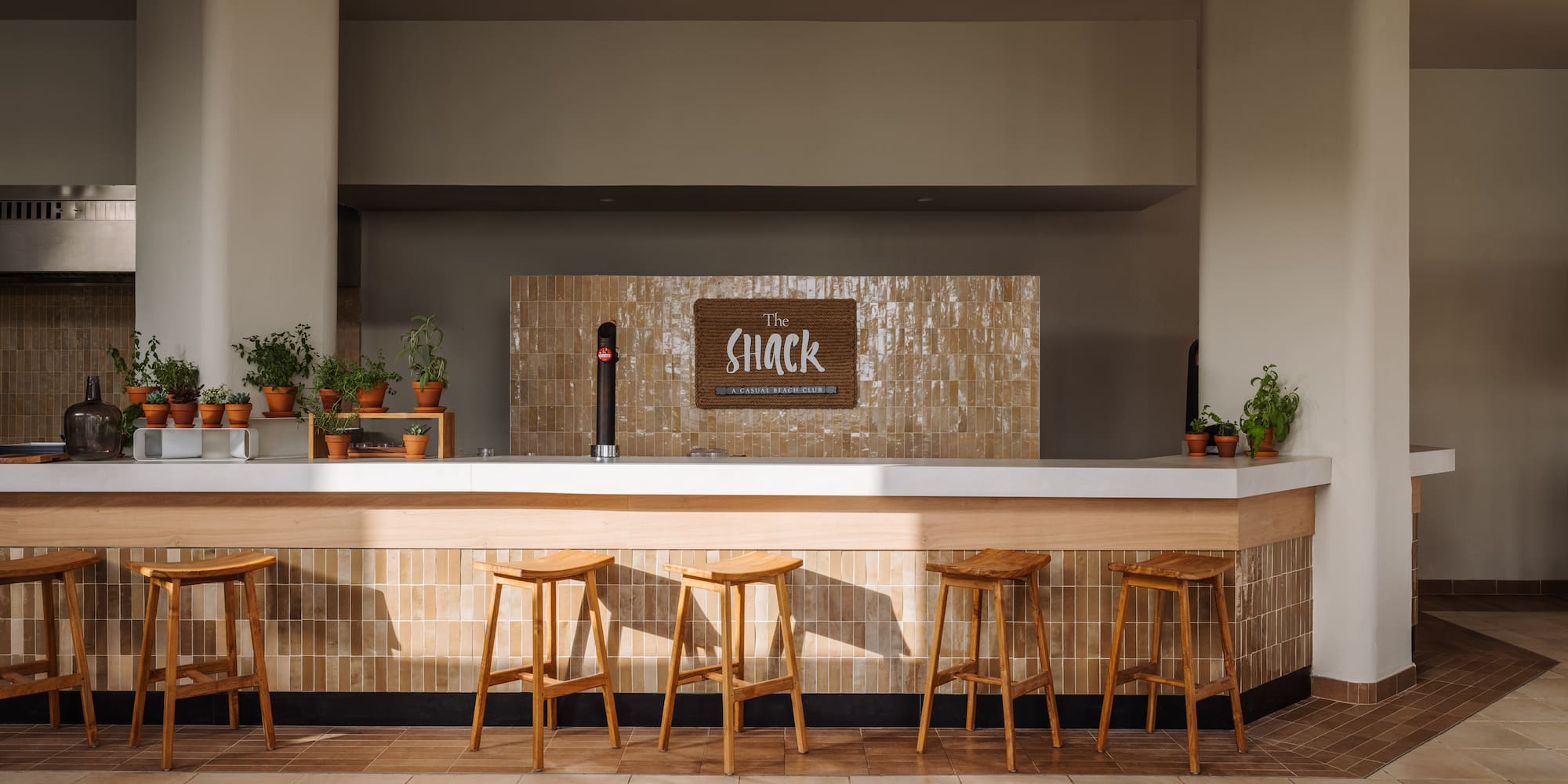 a bar with stools and a sign