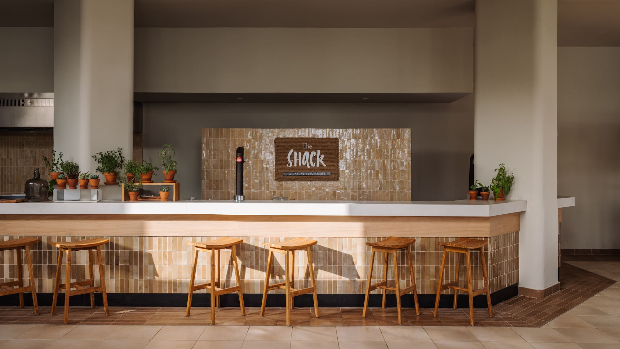 a bar with stools and a sign