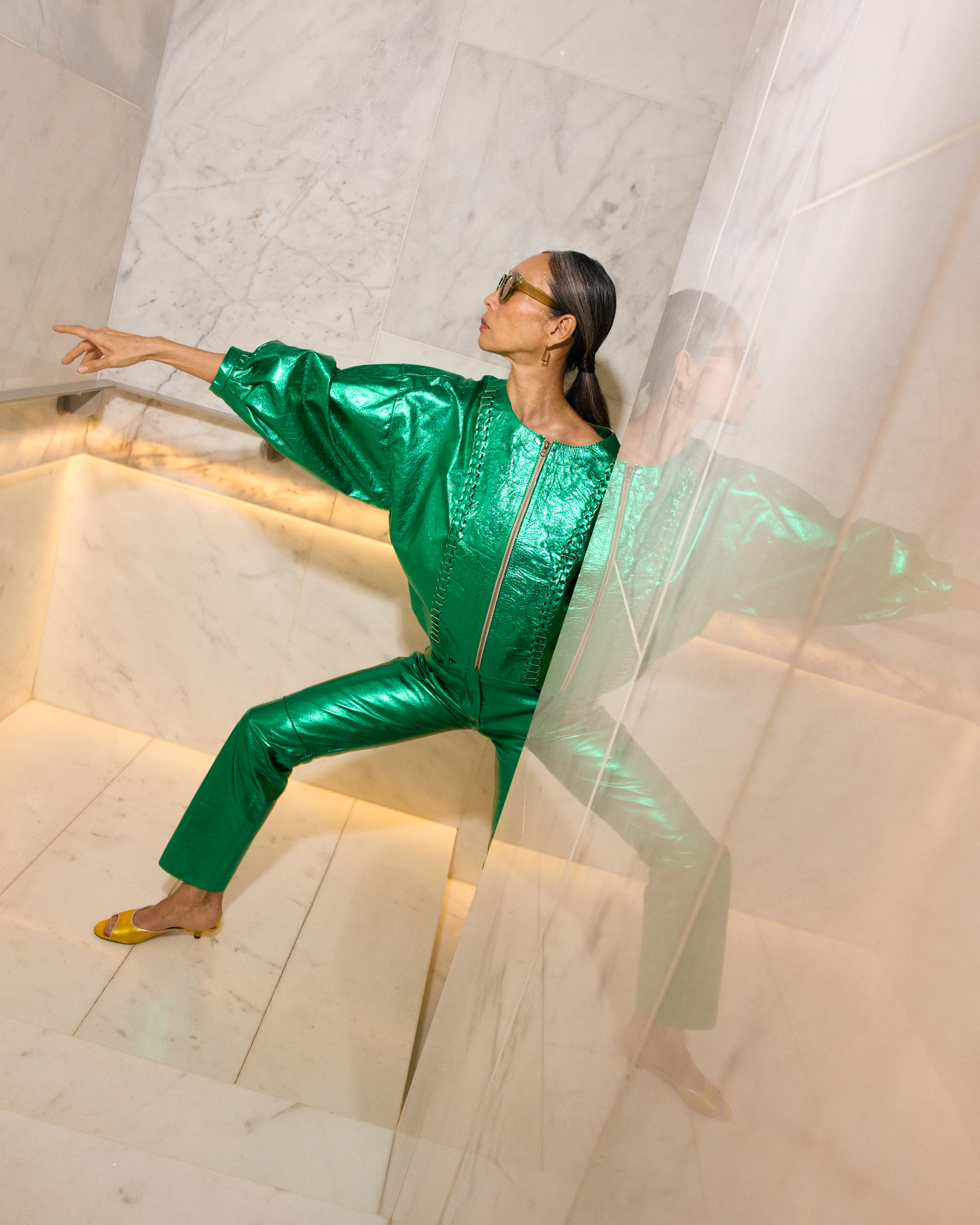 a woman in a green jumpsuit pointing at something