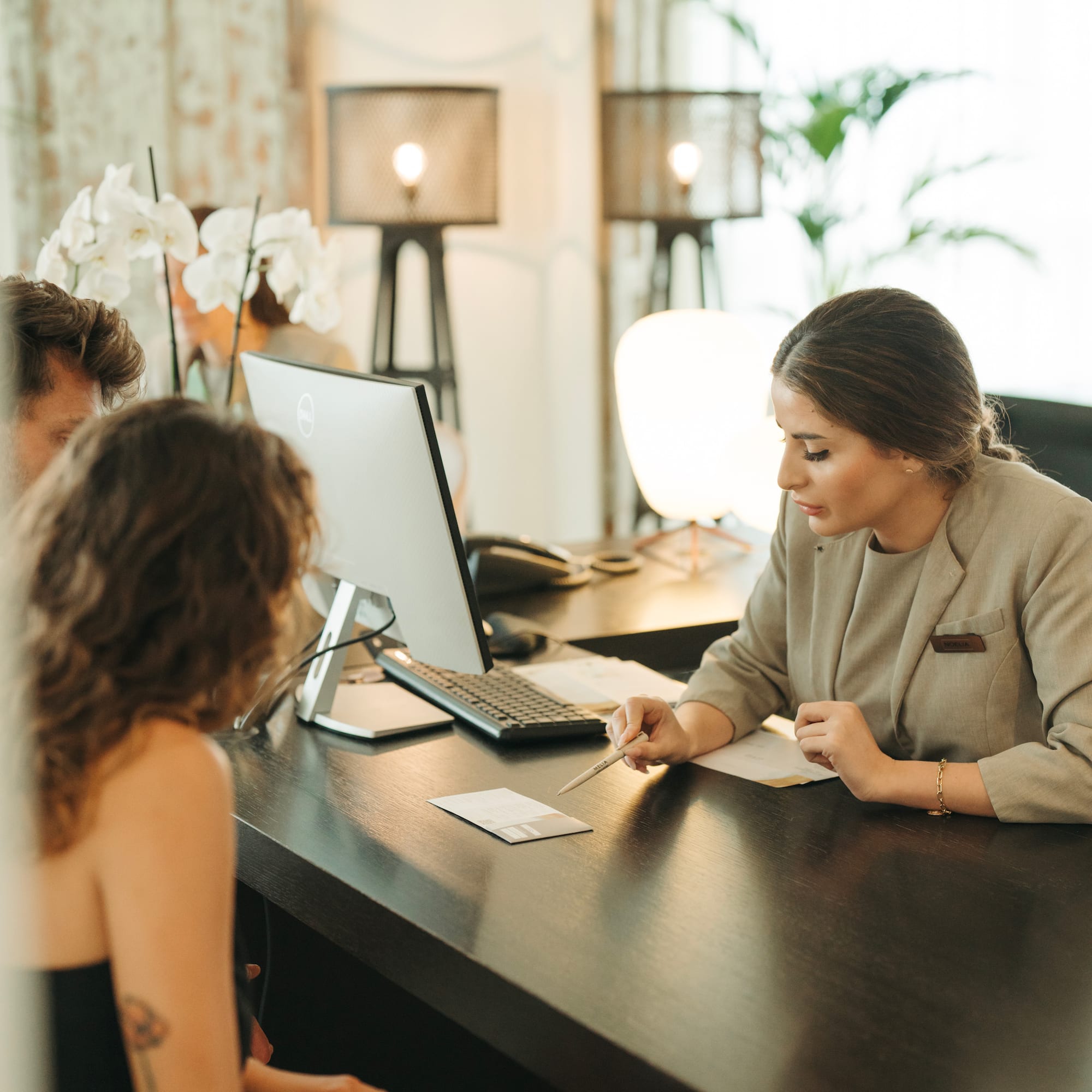 a woman sitting at a desk with a woman looking at a computer