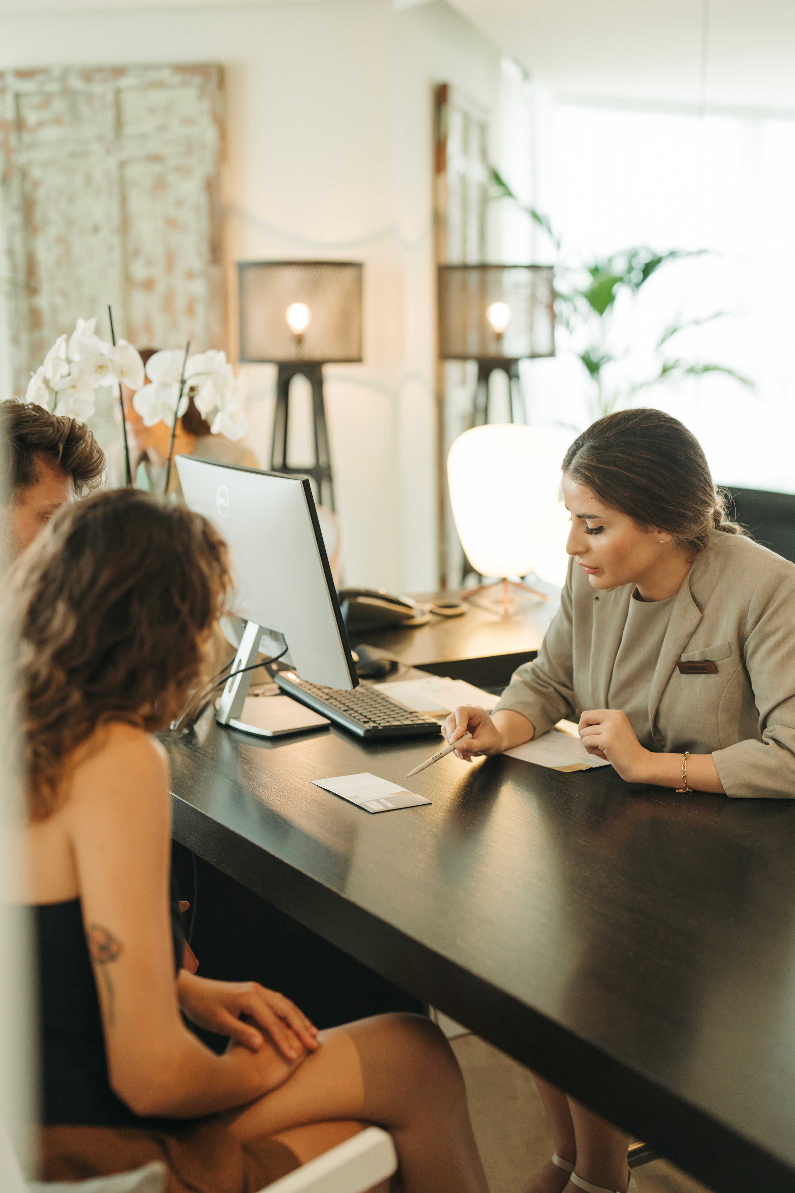 a woman sitting at a desk with a woman looking at a computer