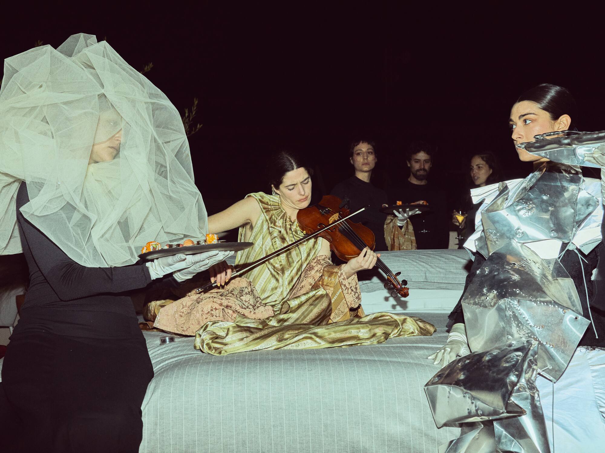 a group of people in clothing playing a violin