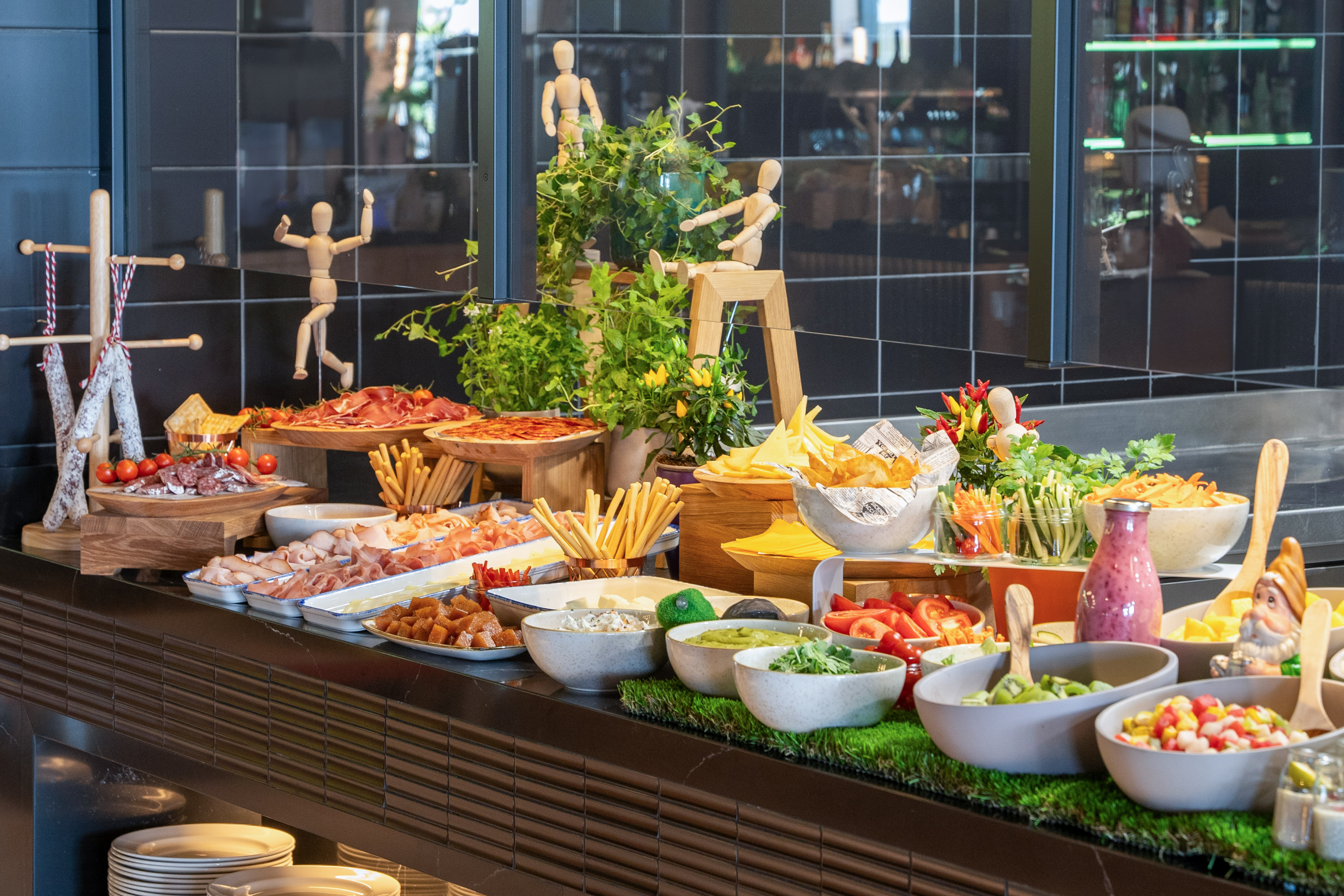 Hotel buffet with charcuterie, cheeses, fresh salads, fruits, and assorted dishes.
