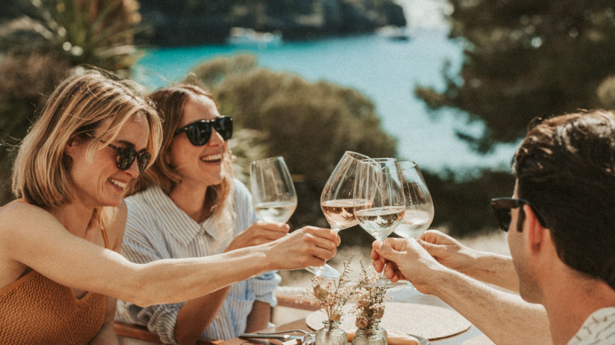 a group of people clinking wine glasses at a table