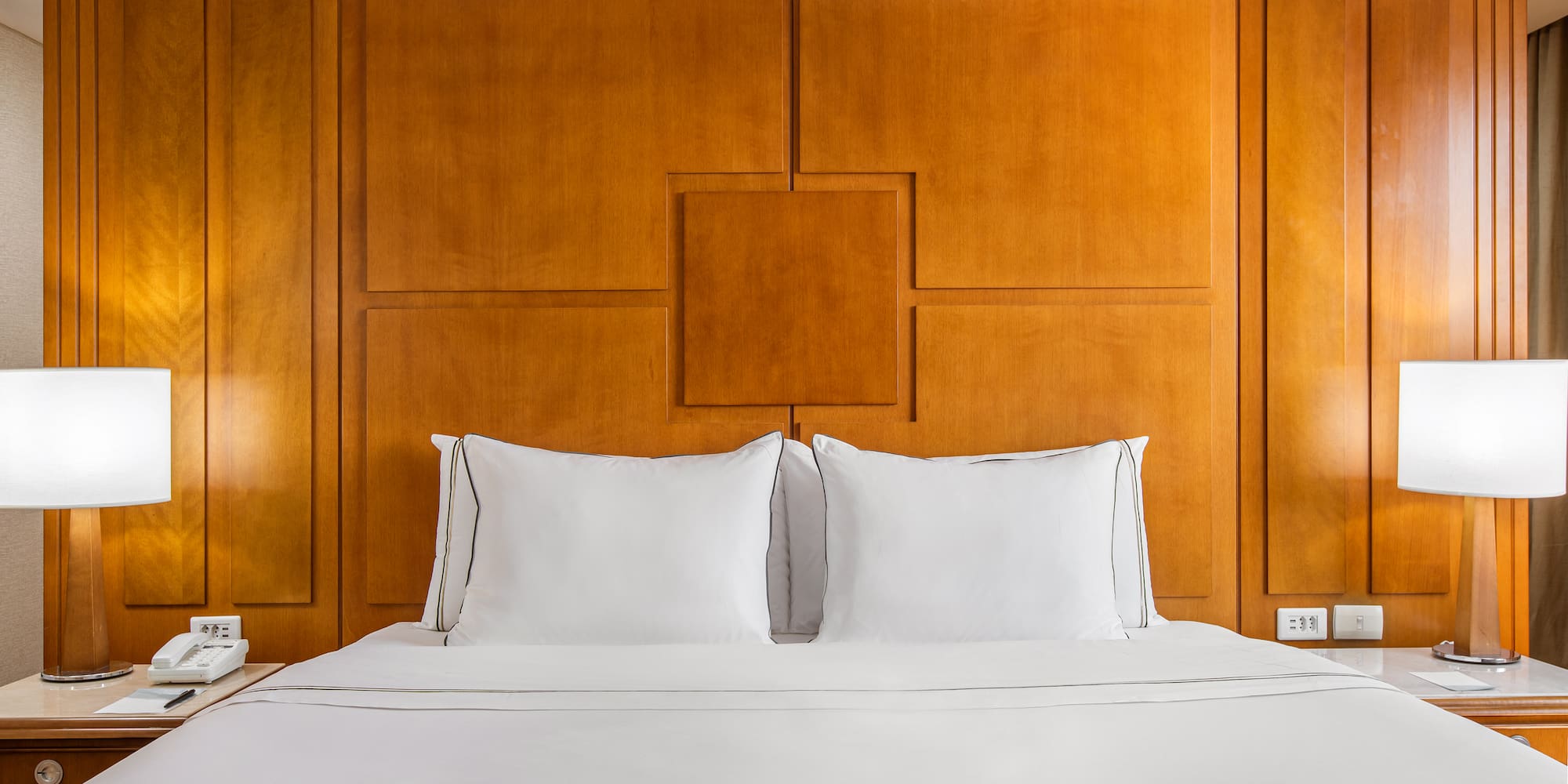 a bed with white sheets and a lamp