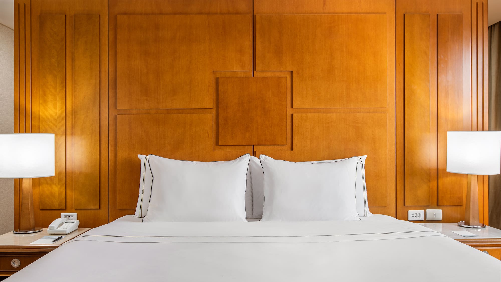 a bed with white sheets and a lamp