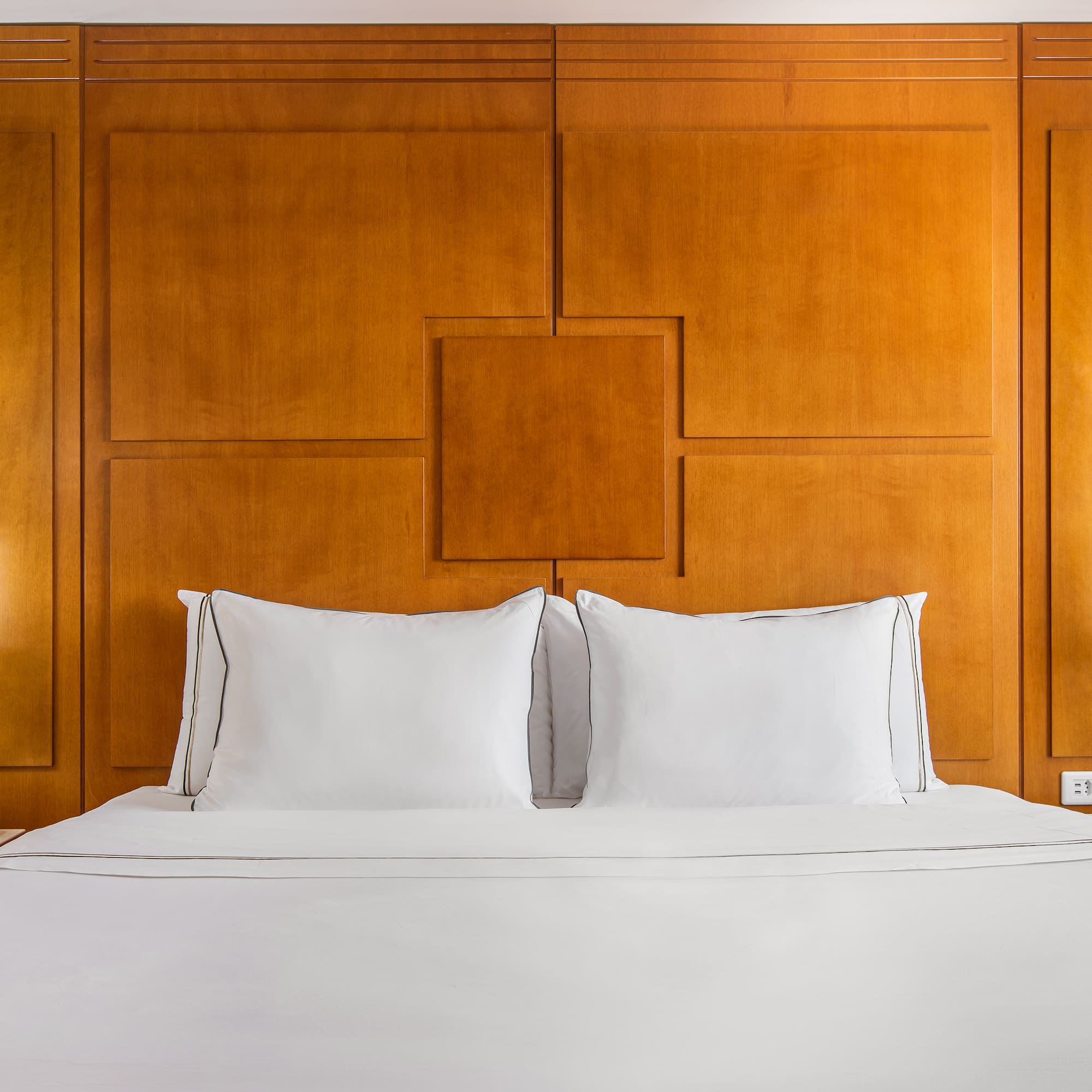 a bed with white sheets and a lamp