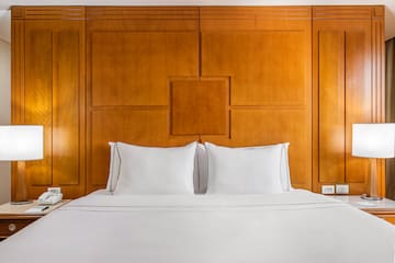 a bed with white sheets and a lamp