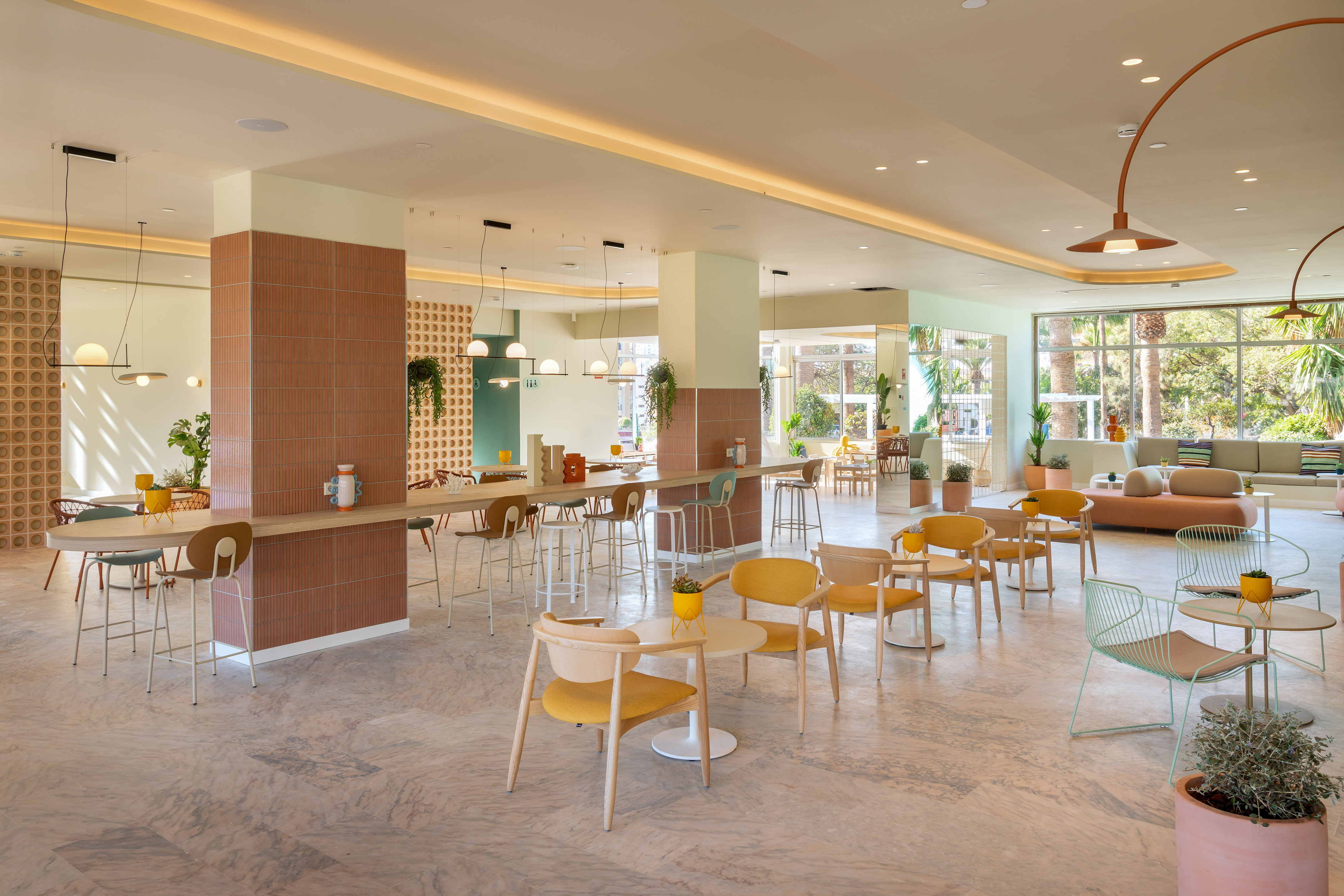 Contemporary hotel lobby or restaurant with colorful seating, terracotta decor.